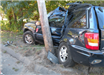 side of black car crashed into wooden pole