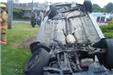 firefighter standing by an upside down car