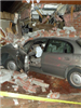 grey car crashed into brick house